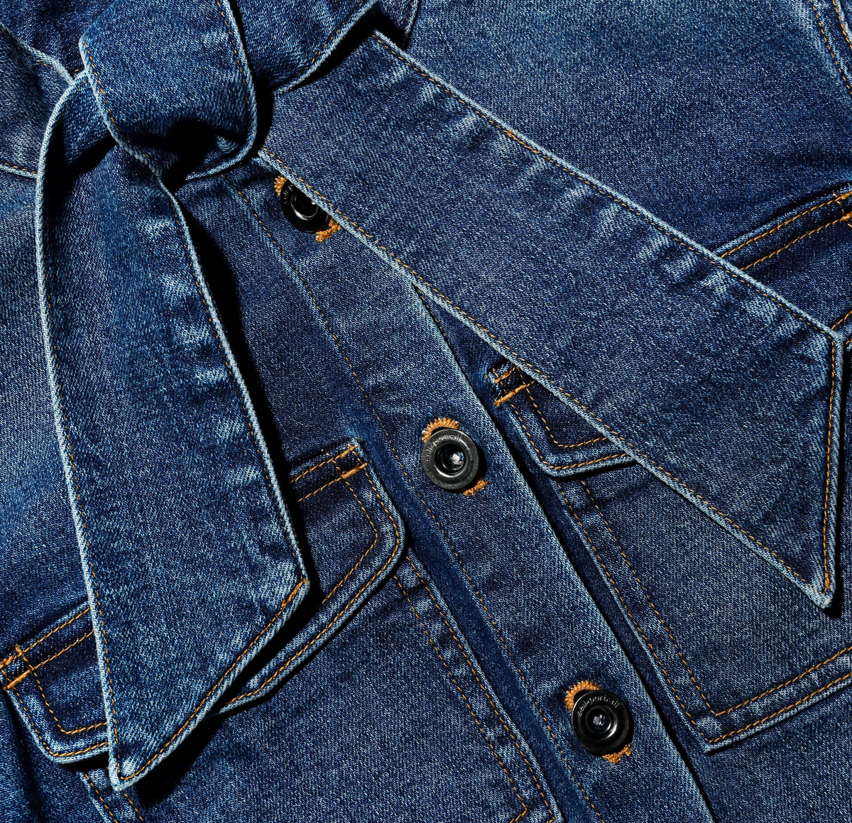 Self-Portrait denim frill playsuit in medium indigo wash, close-up of bow neckline and button front