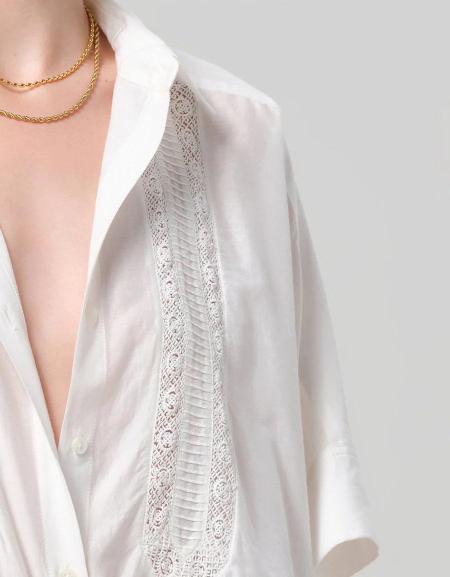 Close-up of the lace inset and pintuck detailing on the front of the white Claire shirt