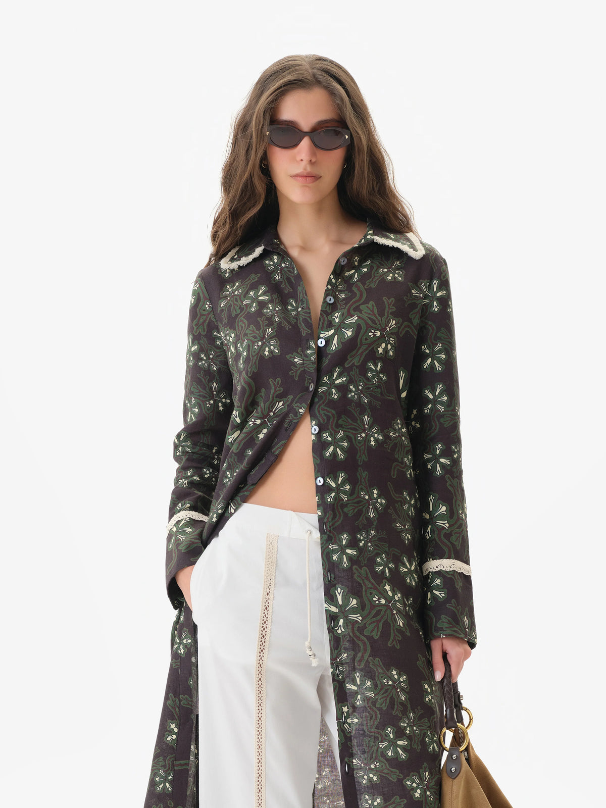 Front close view of the white Savina pants with a lace front panel, styled under a long printed shirt dress
