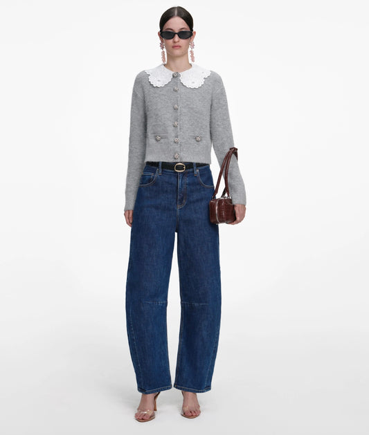 Woman in grey lace cardigan wearing jeans