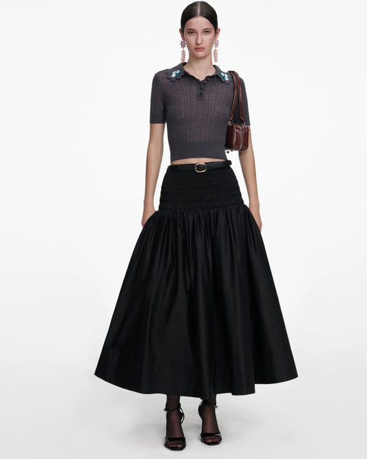 Model wearing knit top and black skirt