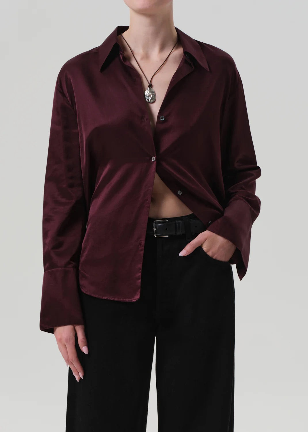 Camilia shirt burgundy worn with black trousers, showcasing its silky fabric and refined style.