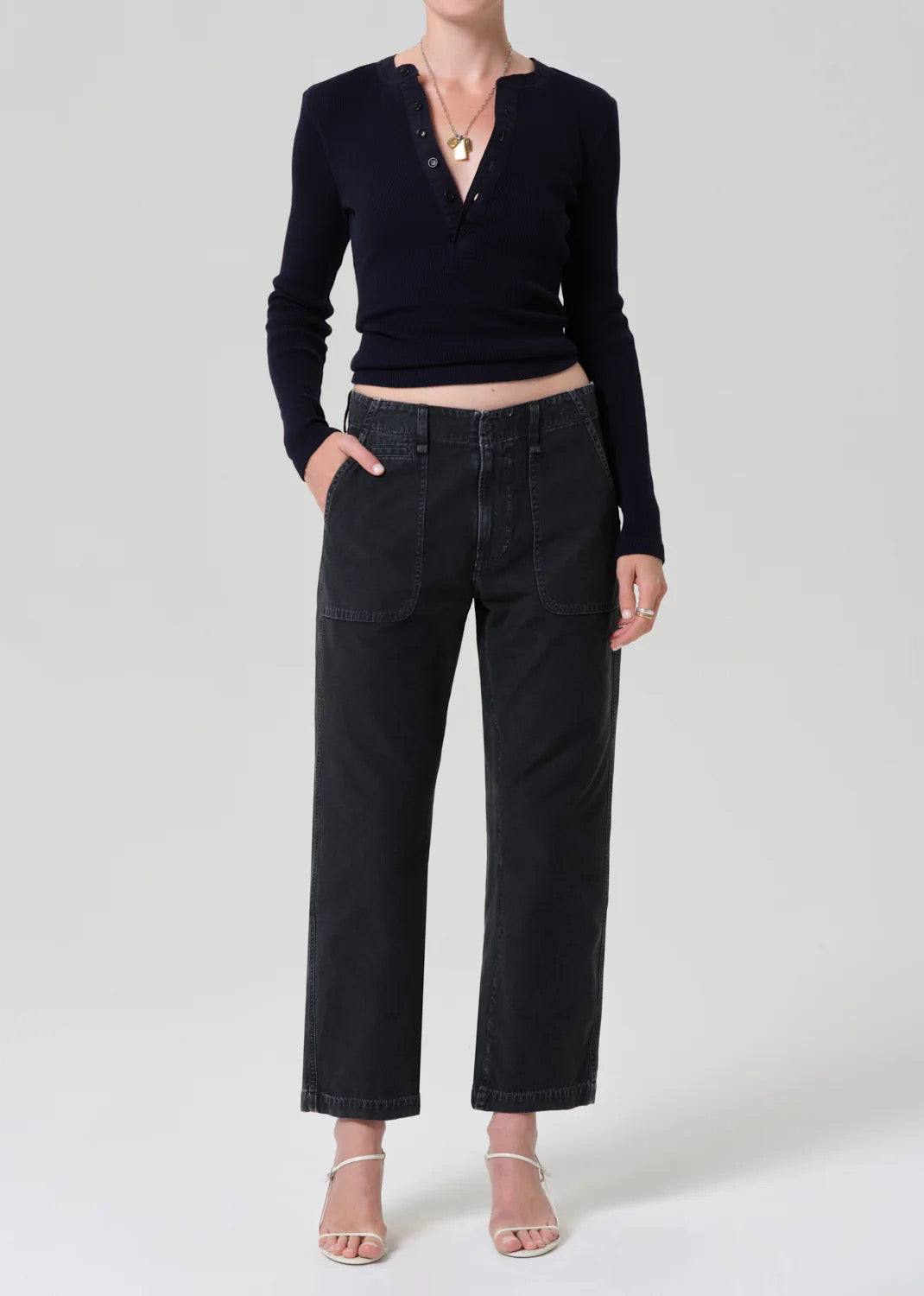 Person wearing a black long-sleeve top and black jeans on a white background