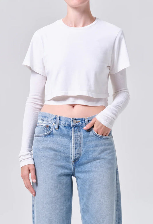 AGOLDE Romily Tee in White Ash, front view on model showing the cropped short-sleeve tee layered over a fitted long-sleeve base, worn with light-wash jeans