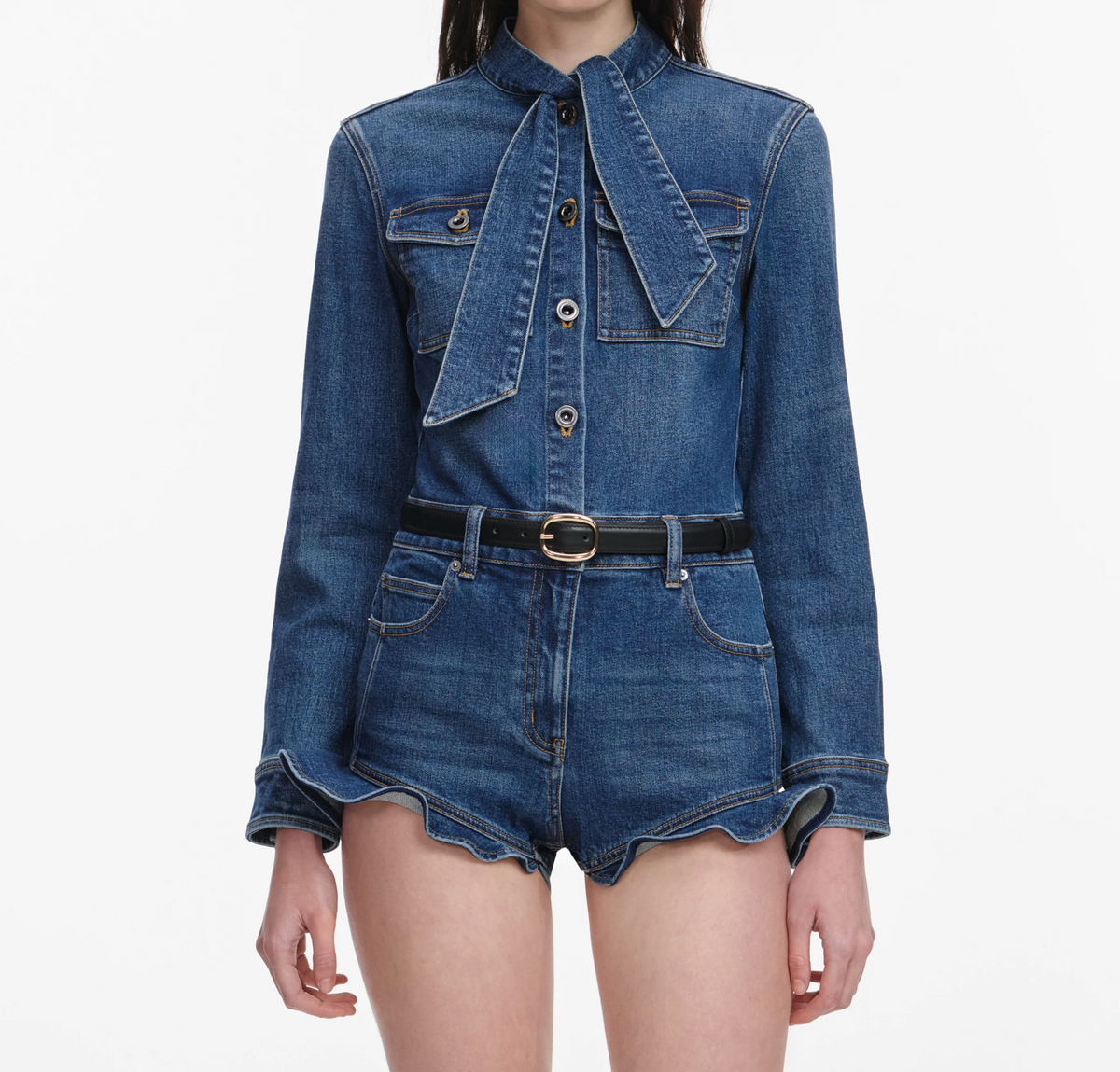 Self-Portrait denim frill playsuit in medium indigo wash, front view showing bow neckline
