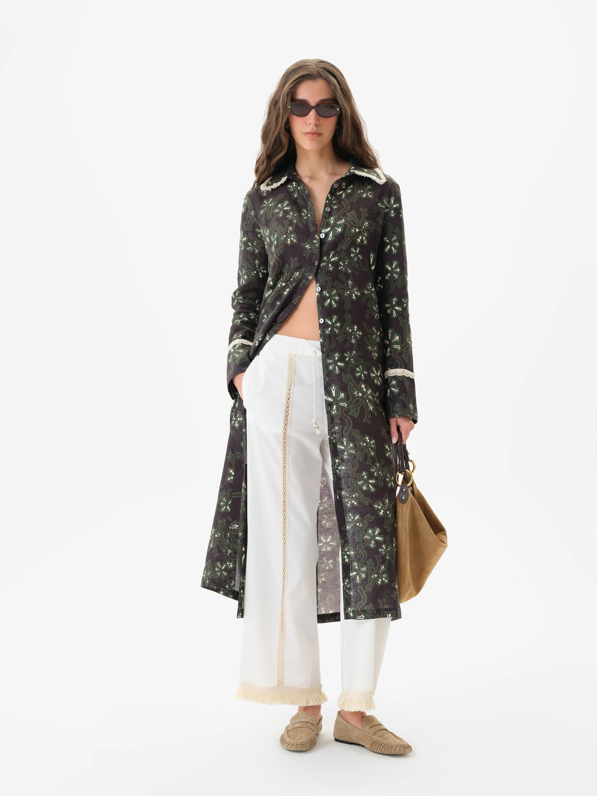 Front view of the white Siedres Savina pants with lace panels and a fringed hem, styled under a long printed shirt dress