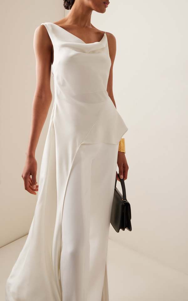 Front view of the ivory Simkhai Ronnie satin top with a cowl neckline, styled with white trousers