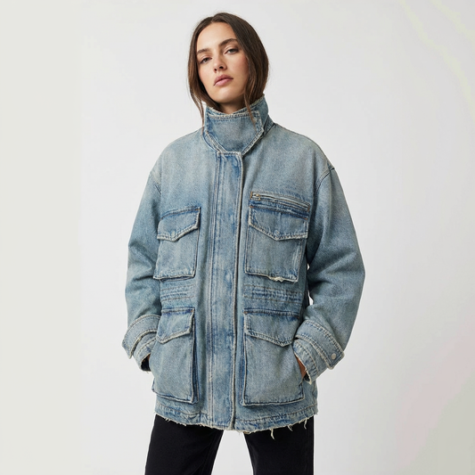 Woman wearing a medium wash denim jacket on a white background